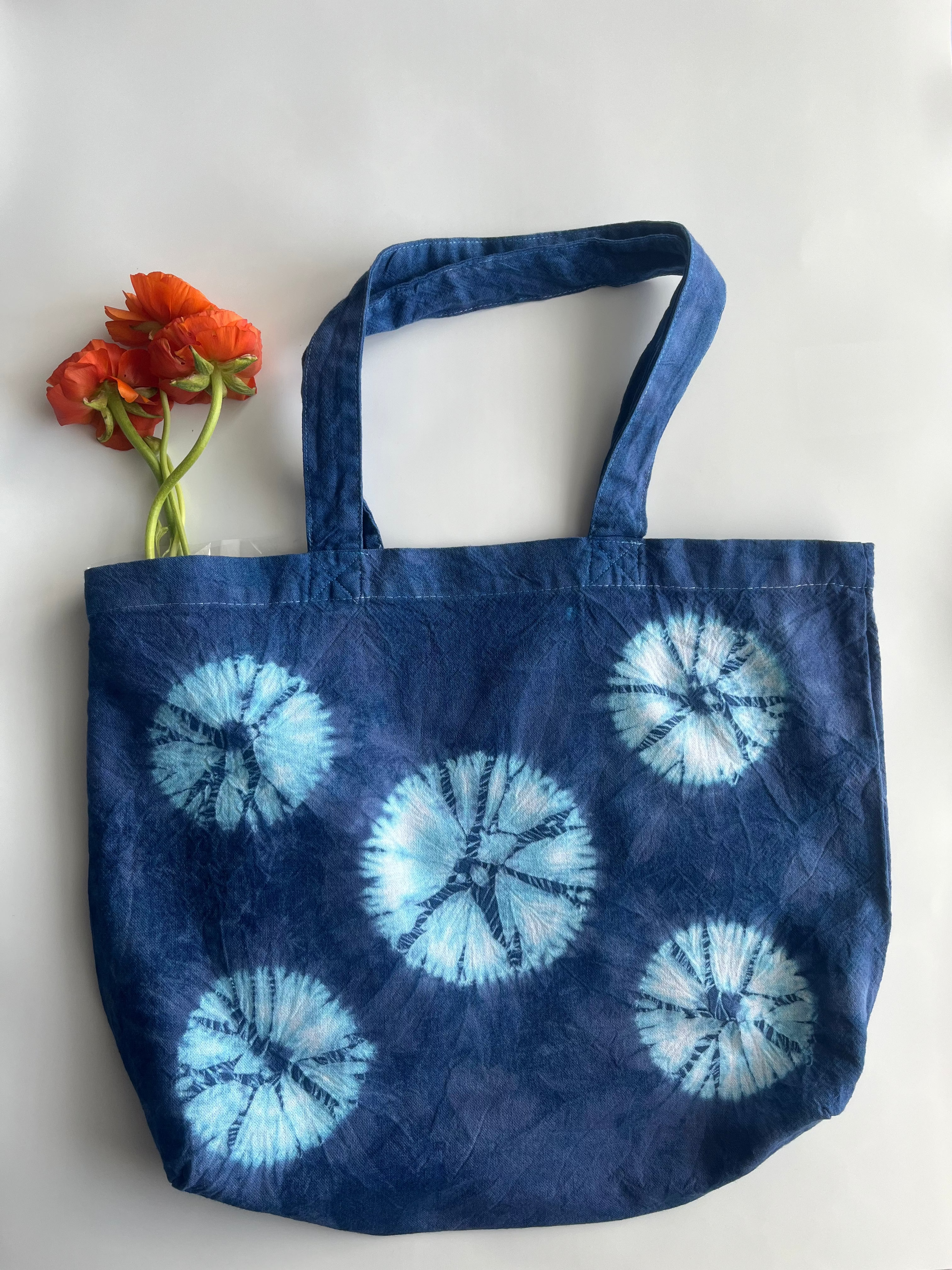 Blue shibori hand dyed tote bag with white circular patterns